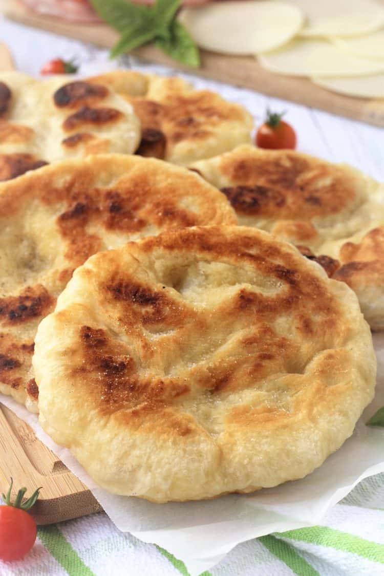 fried pizza dough rounds overlapped on wood board 