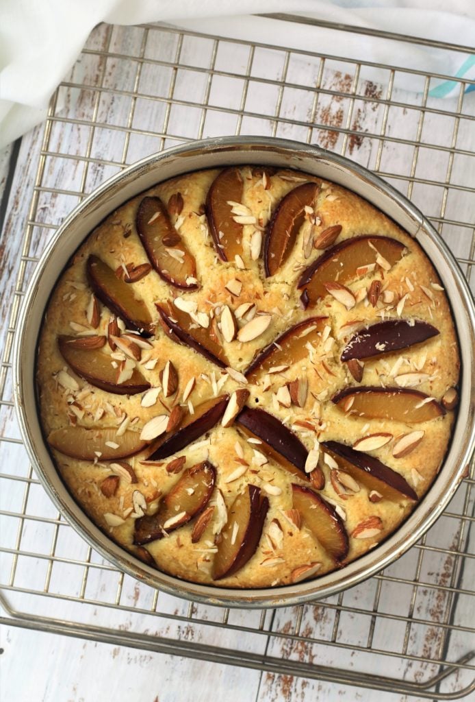 plum almond cake in springform pan on wire rack