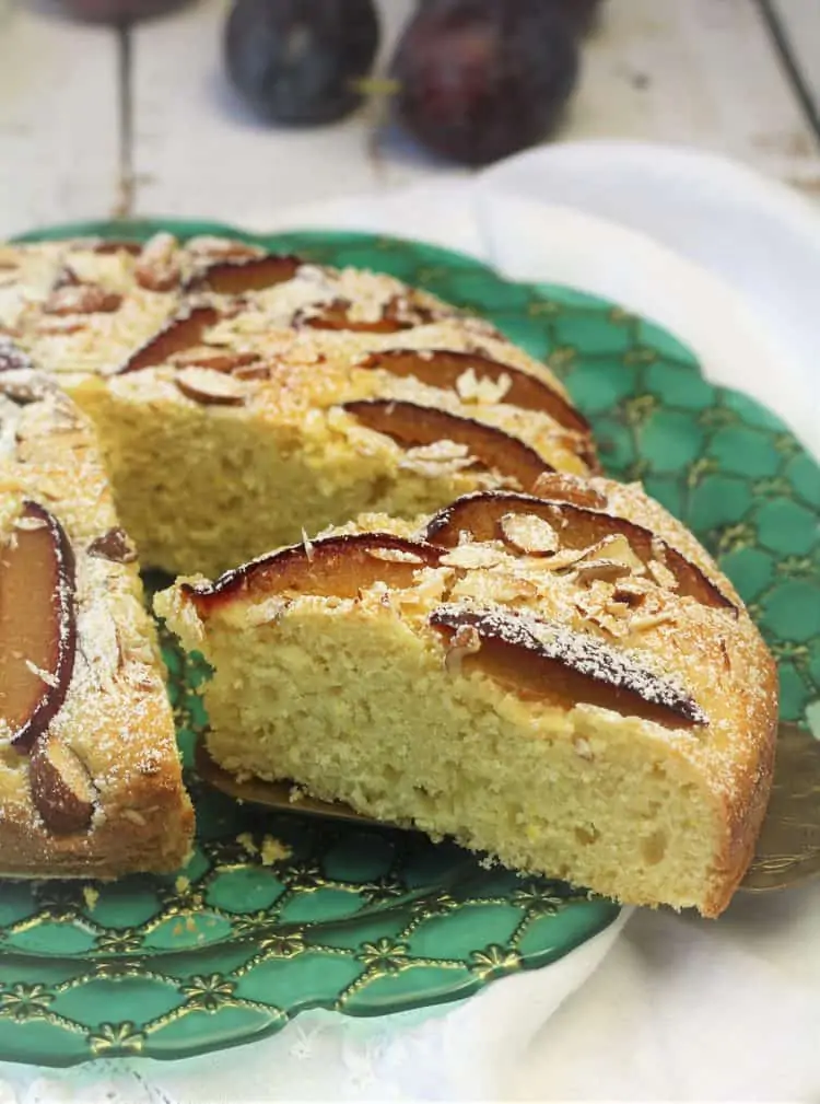 wedge of plum almond cake sliced from whole cake