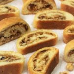 nut and jam rolled cookies on white cloth with hazelnuts