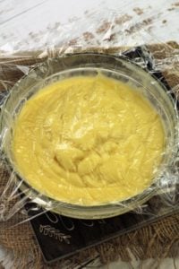 plastic wrap covering pastry cream in glass bowl