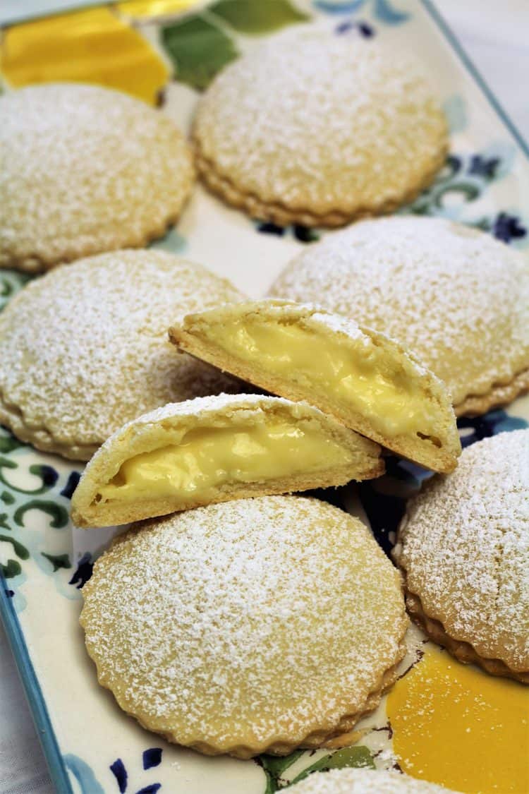 genovesi ericine cookie cut in half to reveal pastry cream filling on tray of cookies