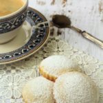 genovesi ericine cookies on lace doily next to coffee cup and spoon