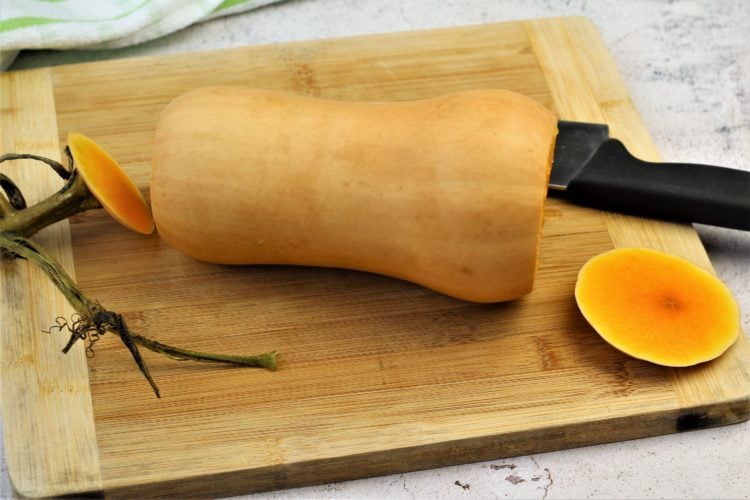 butternut squash with ends cut off on wood board