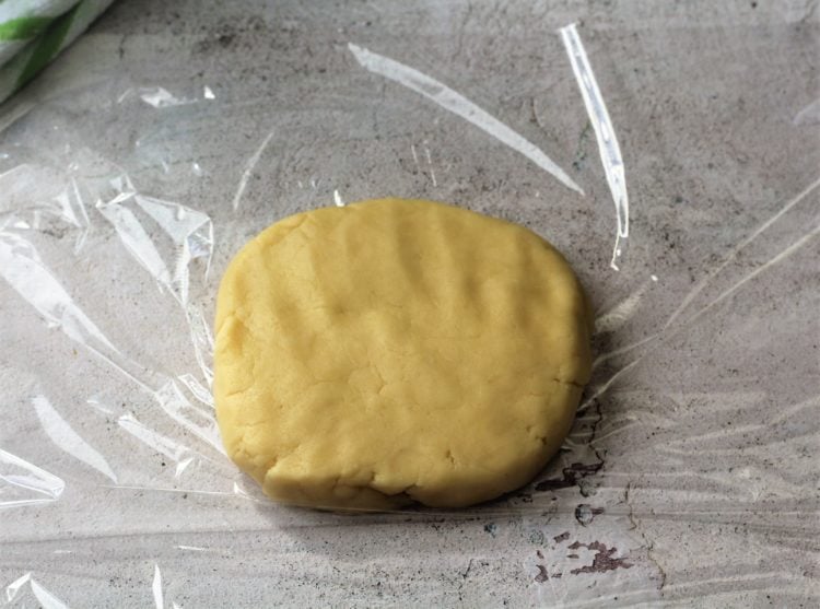 crostata dough shaped into a flat disc on plastic wrap