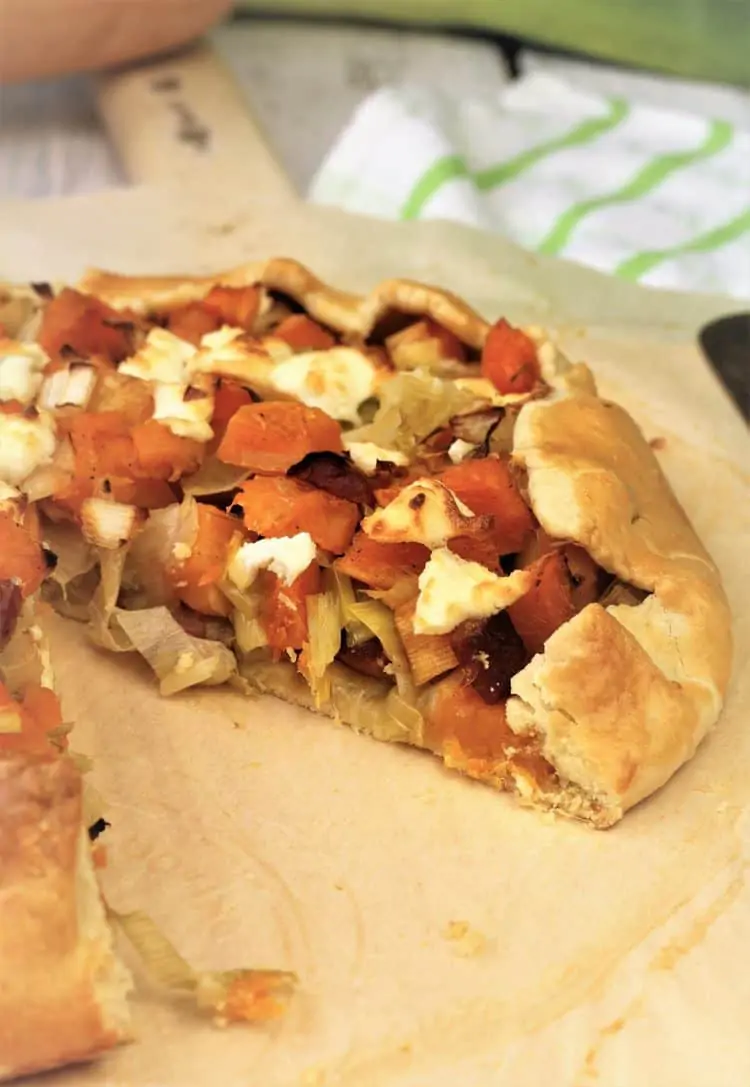 crostata with butternut squash, leeks and goat cheese cut on wood board