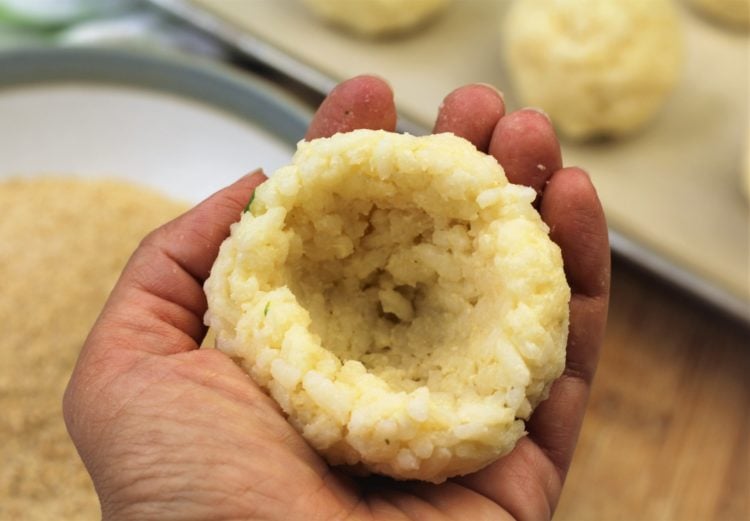 ball of rice cradled with indentation in hand for making arancini