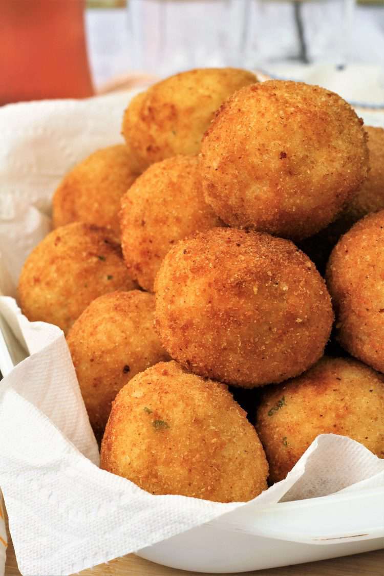 piled arancini, rice balls, in paper towel lined plate