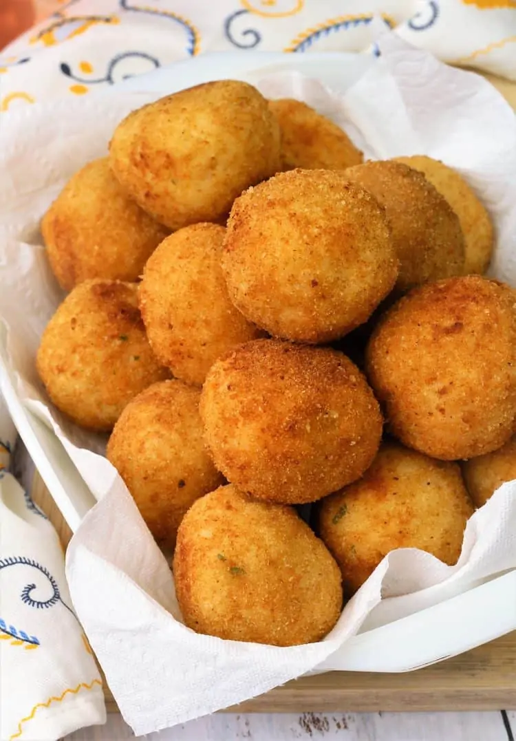 arancini piled on paper towel lined tray 