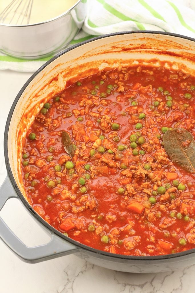 meat ragu with peas in large skillet