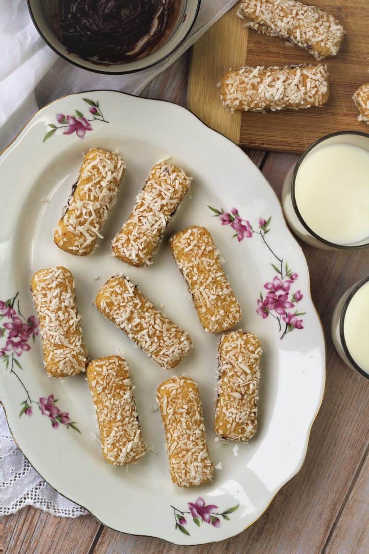 pavesini cookie sandwiches dredged in coconut flakes on serving plate