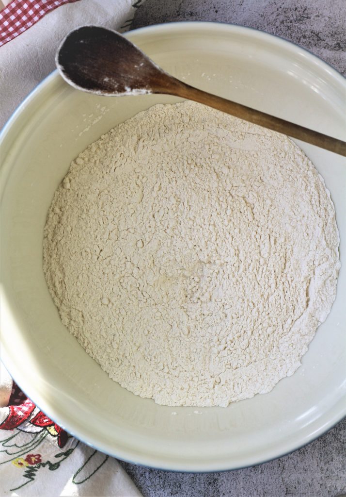 flour in large mixing bowl with wooden spoon