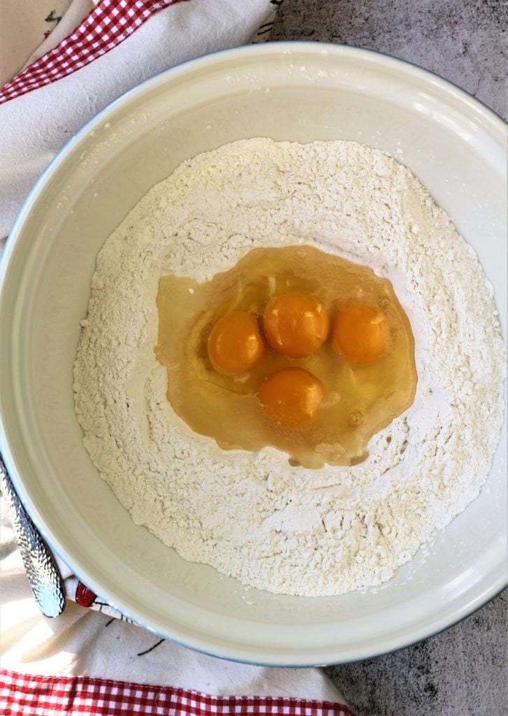 eggs poured into well of flour in large mixing bowl