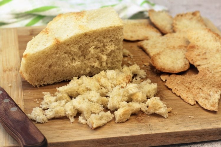 loaf of italian bread with crusts cut off and crumbled