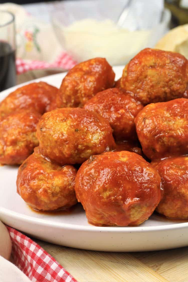 meatballs with tomato sauce piled on white round plate