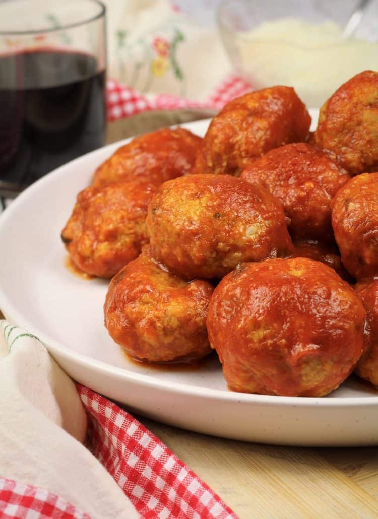 piled meatballs with tomato sauce on serving plate