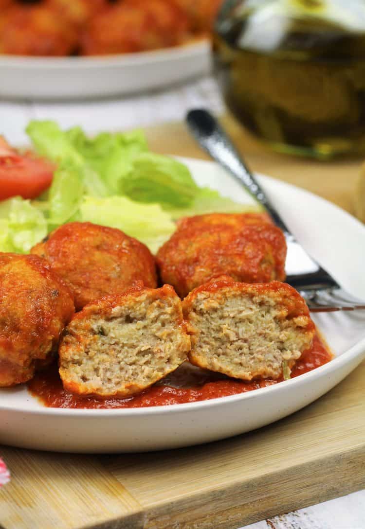 meatball halved and served on plate with salad