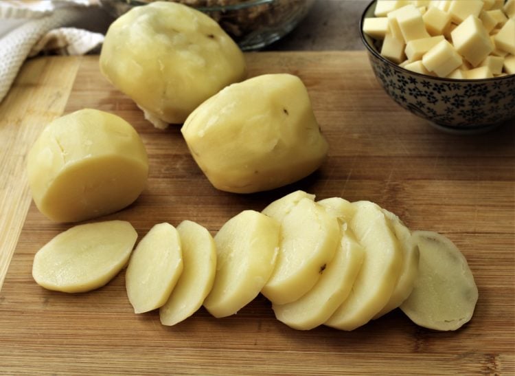boiled potatoes sliced on wood board