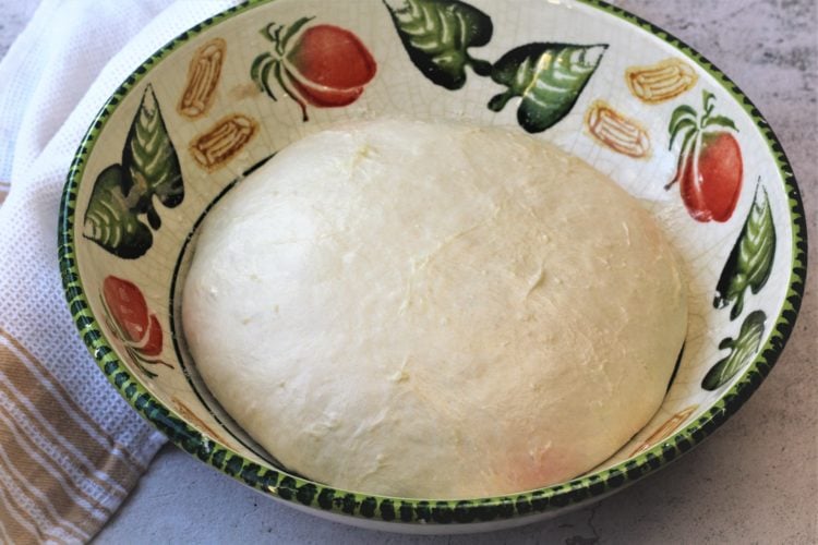 pizza dough ball in large colorful bowl