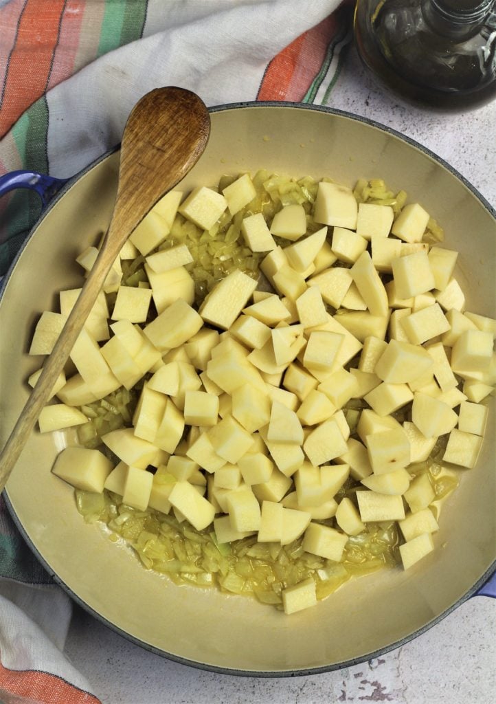 cubed potatoes in large skillet with diced onion
