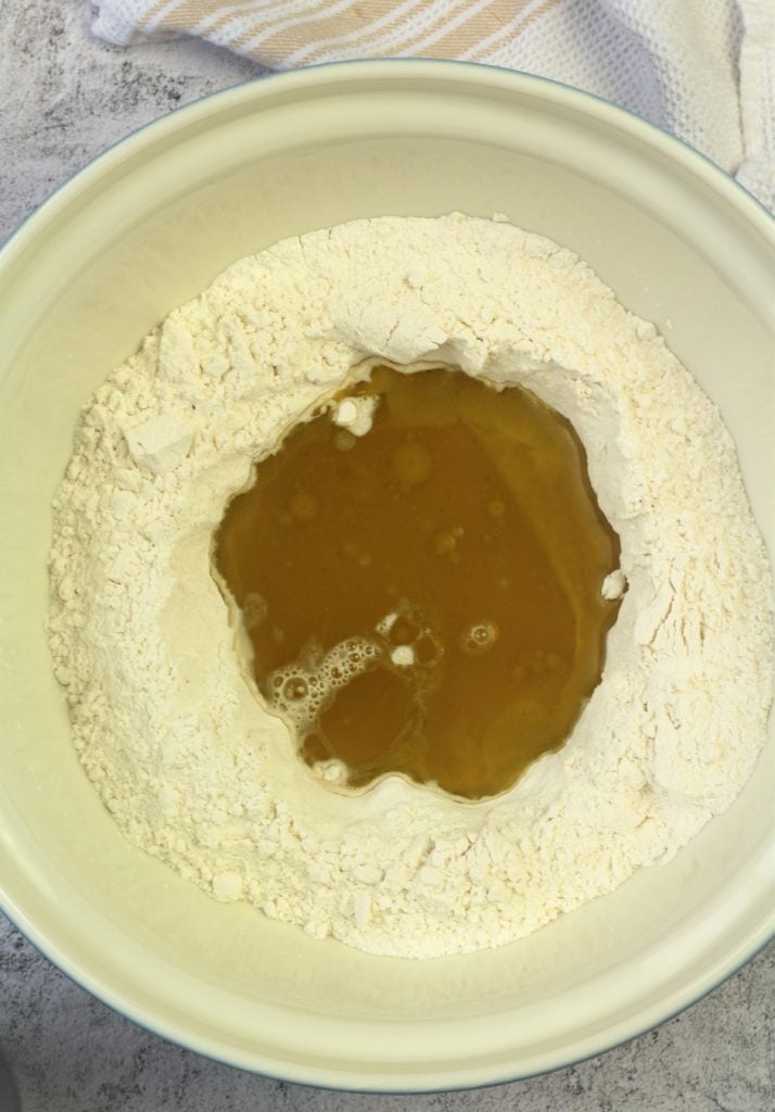 bowl of flour with oil and wine poured in the center