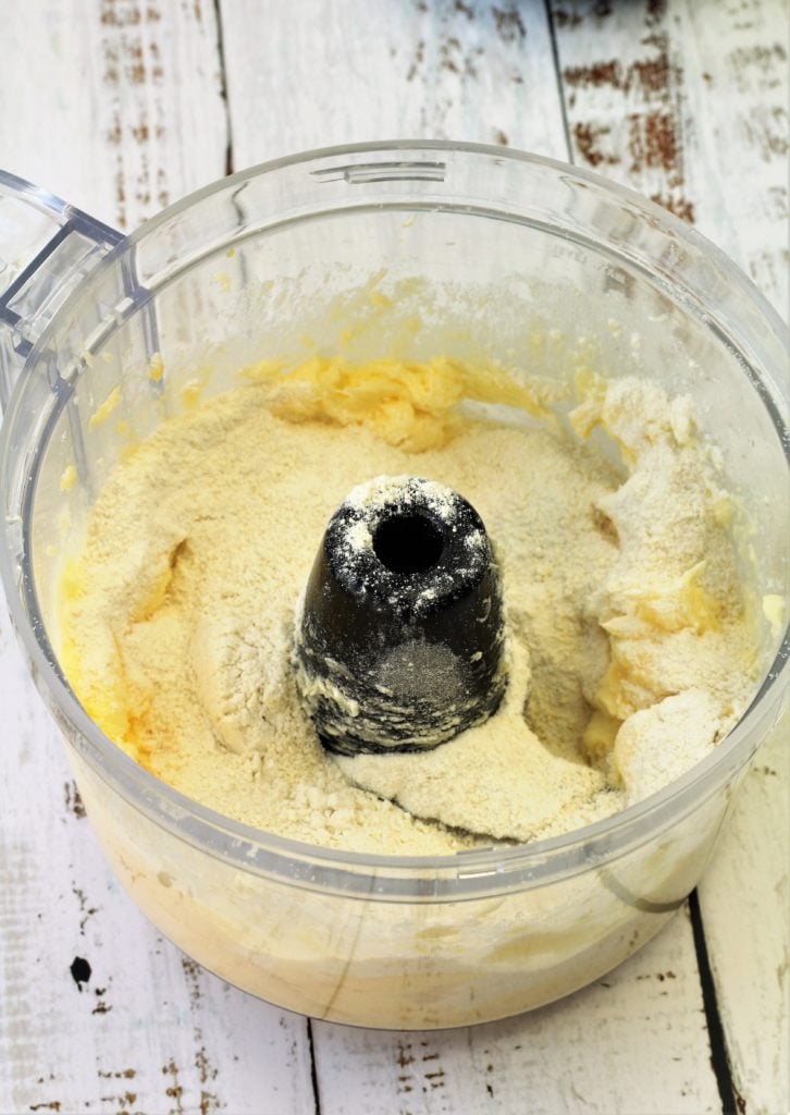 flour added to food processor bowl with creamed butter and sugar