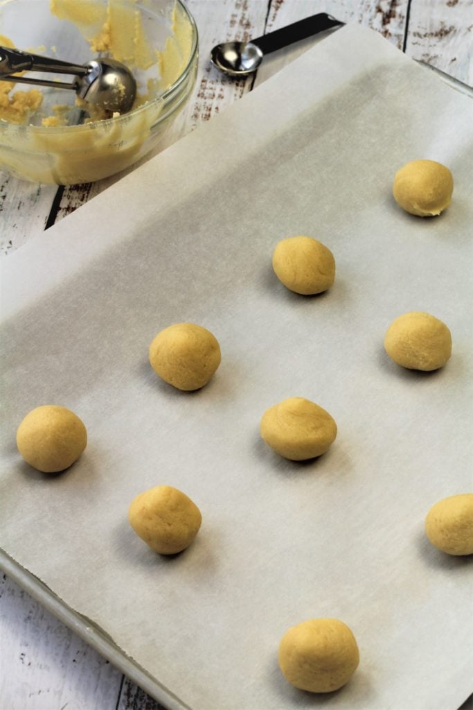 balls of thumbprint cookie dough on baking sheet