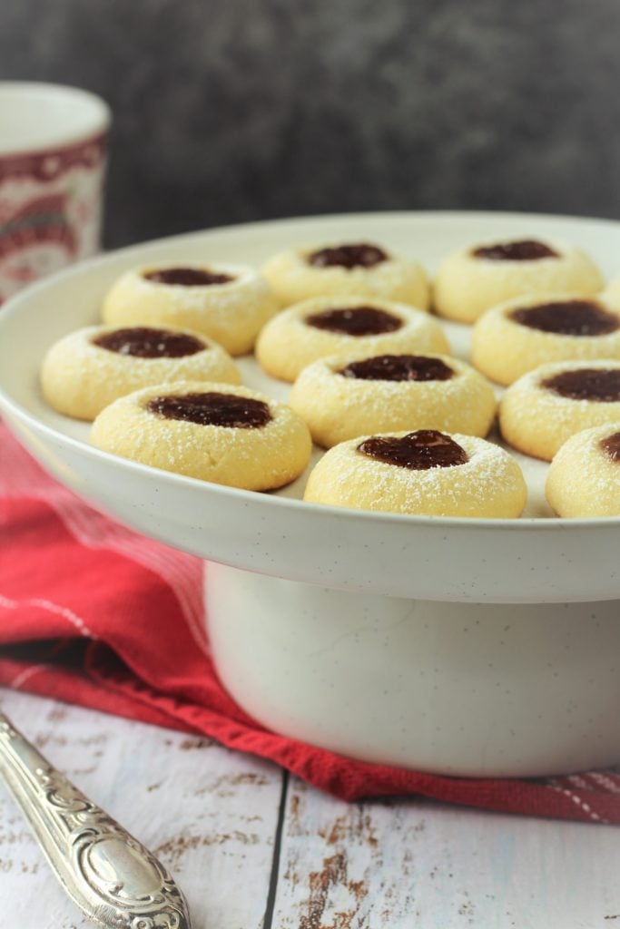 round cake stand filled with raspberry filled thumbprint cookies