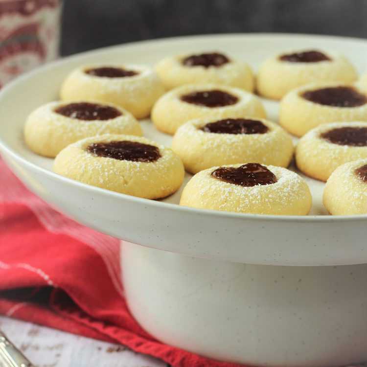 raspberry almond thumbprint cookies on round cake stand