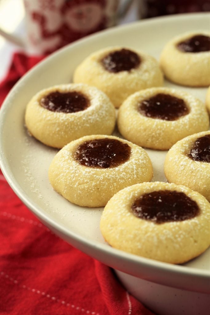 raspberry almond thumbprint cookies on round white plate