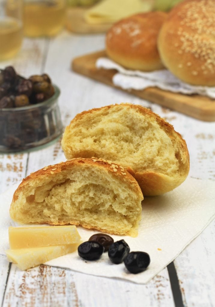 semolina roll cut open alongside olives and cheese slices