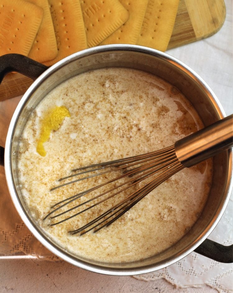 whisked milk with cinnamon and lemon rind in sauce pan