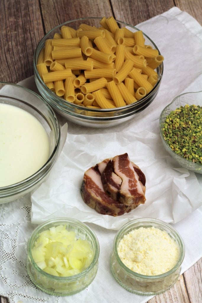 ingredients for pistachio pasta: pasta, pancetta, pistachio pieces, cream, onion and grated cheese