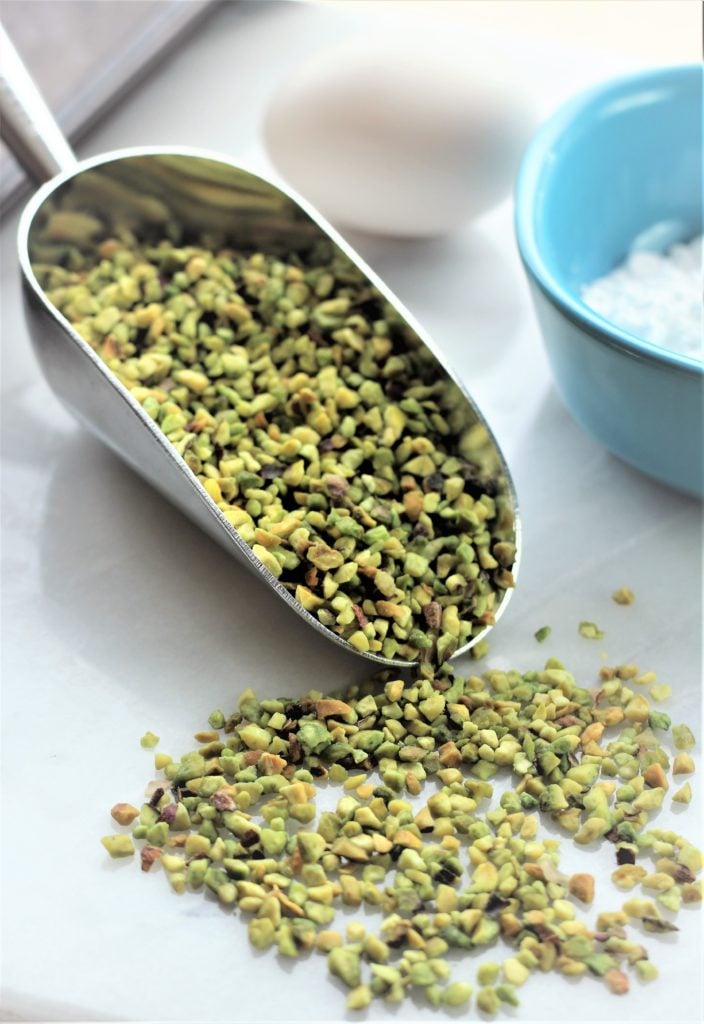 chopped pistachio pieces on metal scoop