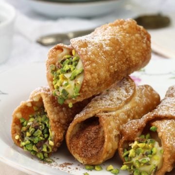 pastry cream filled cannoli piled on plate