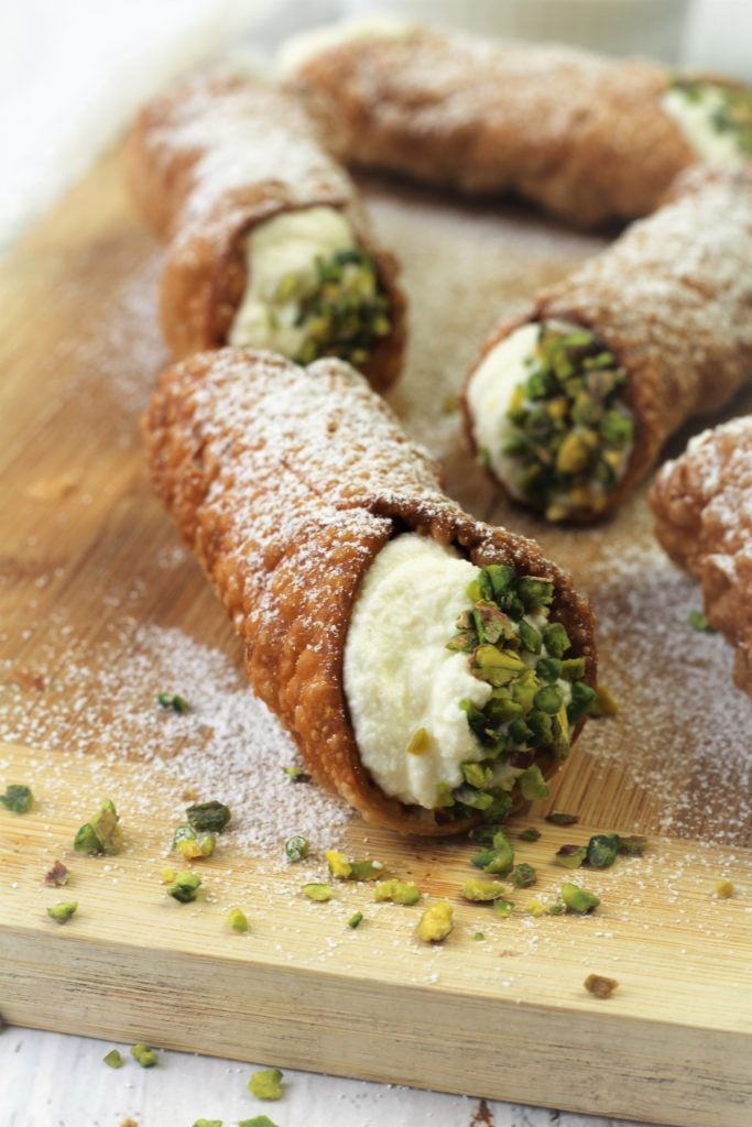 cannoli filled with ricotta and topped with chopped pistachios