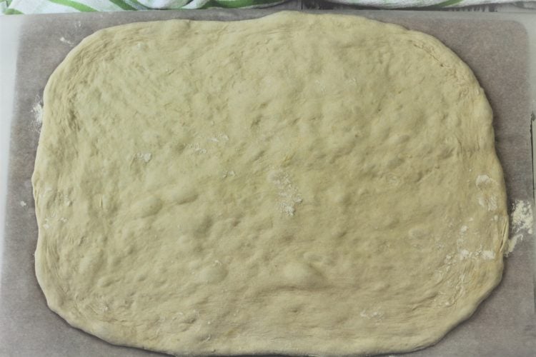 pizza dough flattened in a rectangular shape