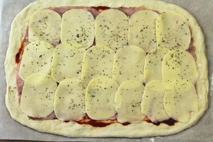pizza dough topped with sliced provolone