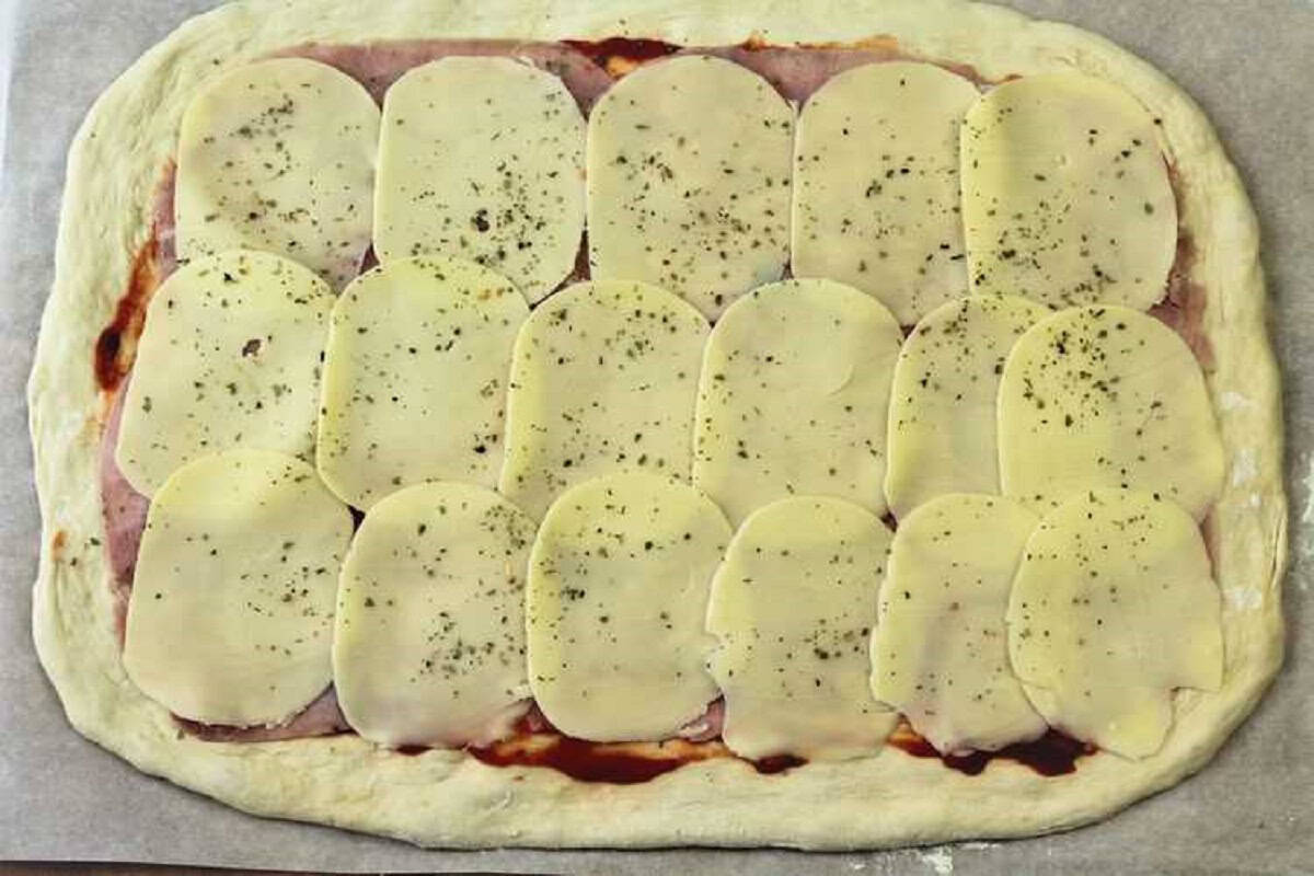 Provolone slices on pizza dough for pizza rolls.