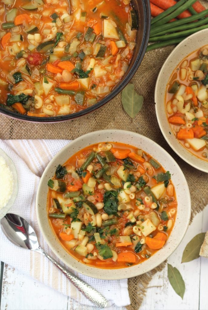 bowls of minestrone soup along pot filled with soup