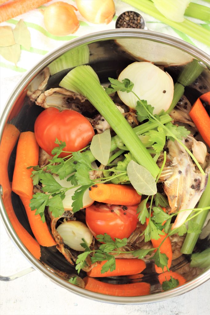 large stock pot filled with vegetables and chicken for chicken broth