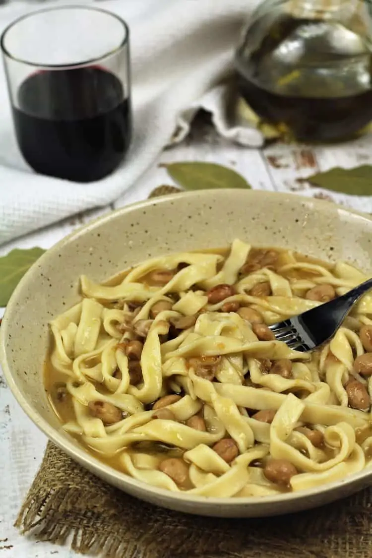 bowl of tagliarini with beans and fork in it