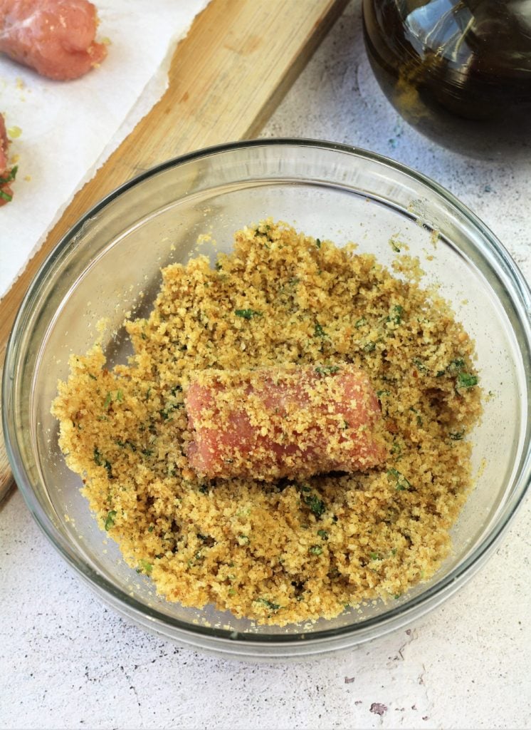 veal involtini dredged in bowl of breadcrumbs