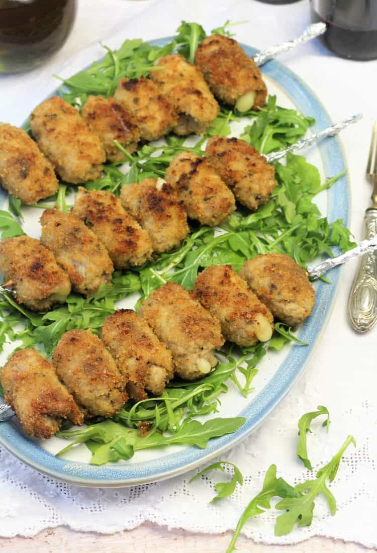 skewered veal involtini on a bed of arugula