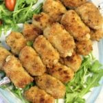 braciole messinese on platter with arugula and tomatoes