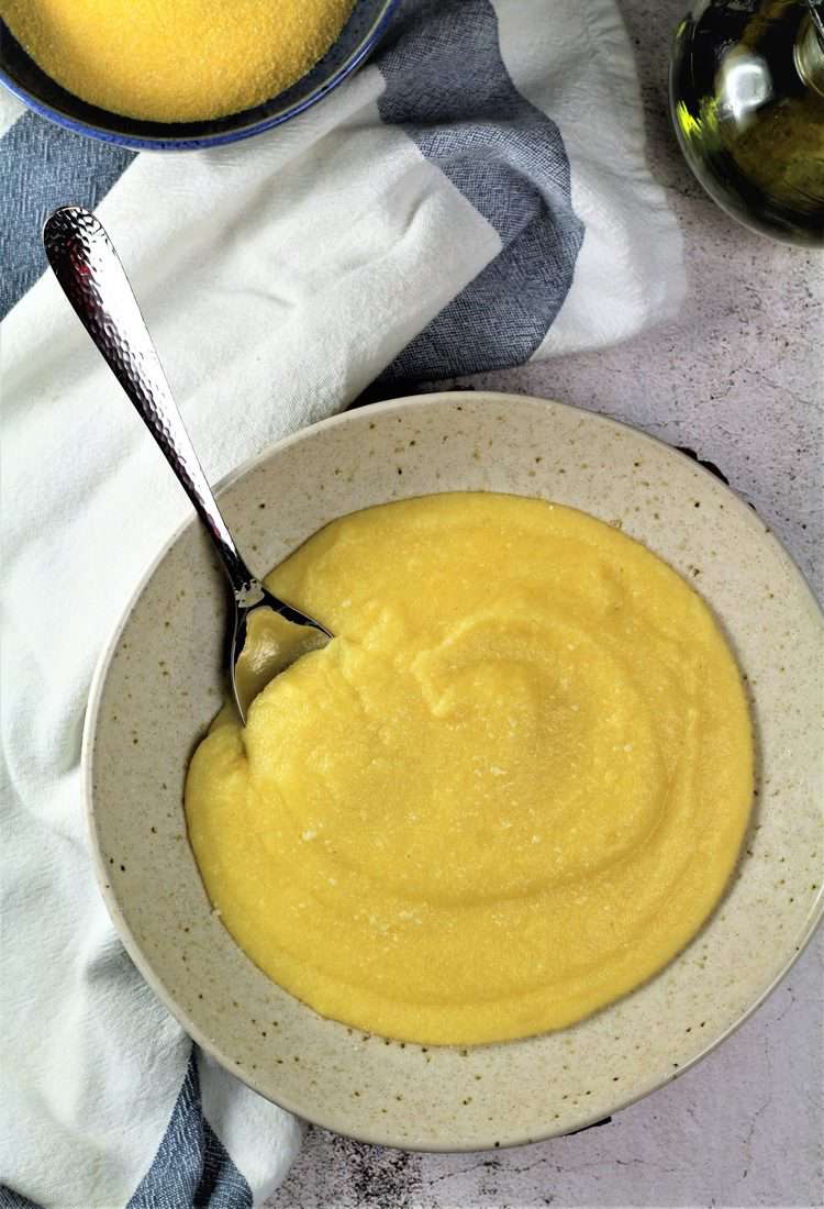 creamy polenta in bowl with spoon 