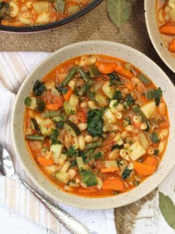 Bowls of Italian vegetable bean soup with spoon.