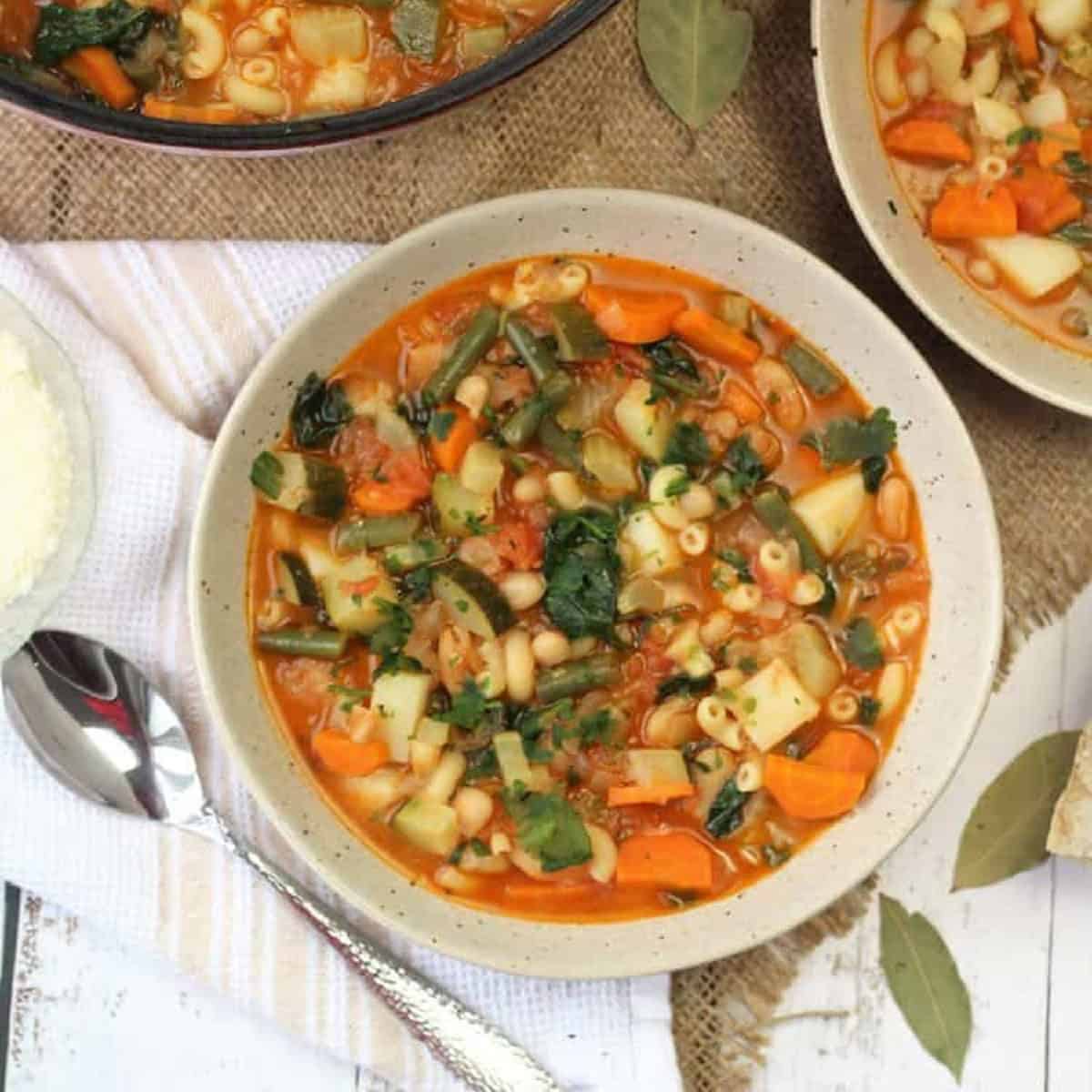 Bowls of Italian vegetable bean soup with spoon.