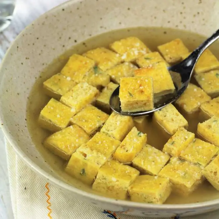 bowl of cubed frittata in broth with spoon full