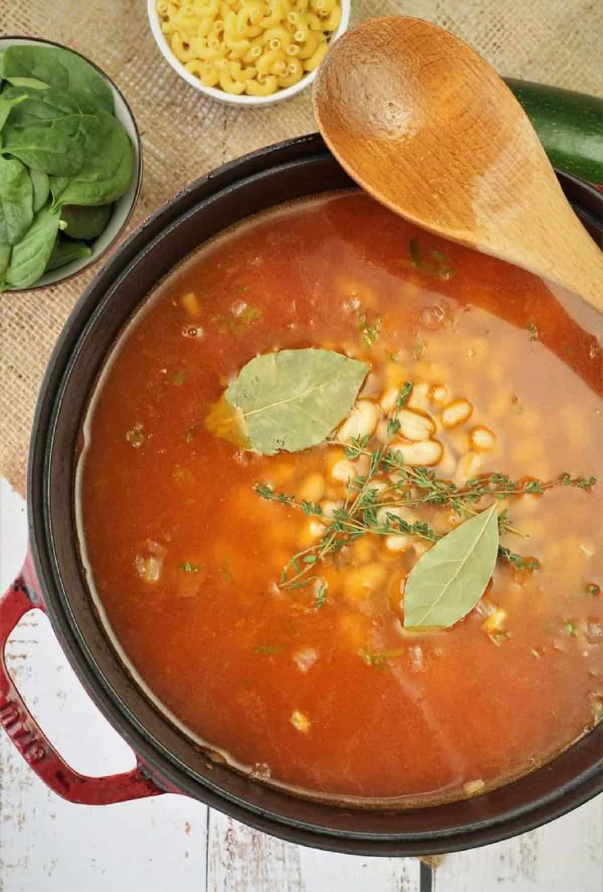 Water and aromatics added to sauce pan for minestrone recipe.